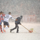 US defender Geoff Cameron helps a groundskeeper shovel the pitch.